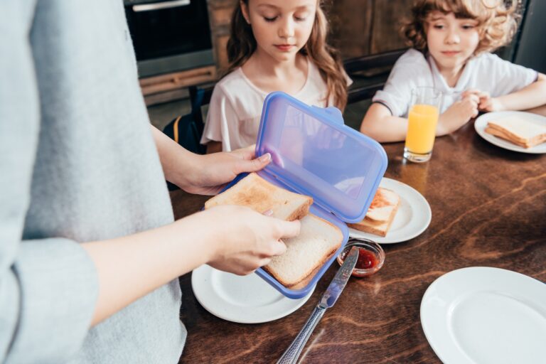 mother packing school lunch in box for children
