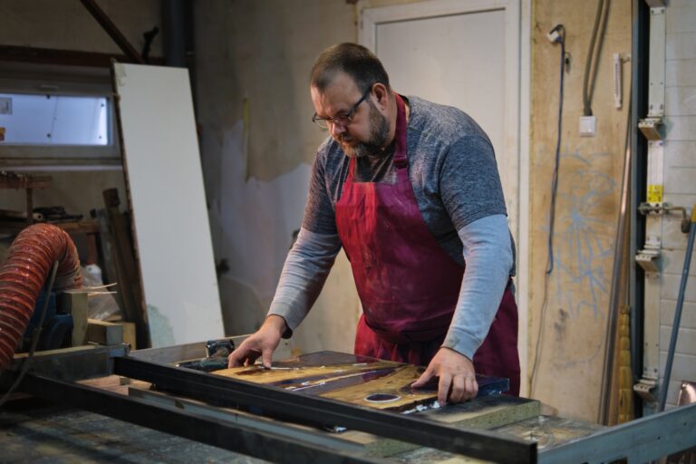 Worker examines joinery; precision, expertise. It underscores the value of skilled labor in an